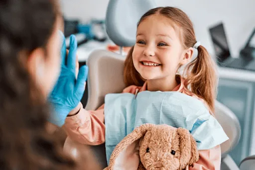 Child smiling at a kids dentist appointment