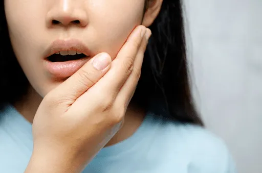 Woman holding her jaw in pain from a dental emergency