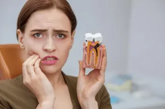 Person holding their jaw in dental pain