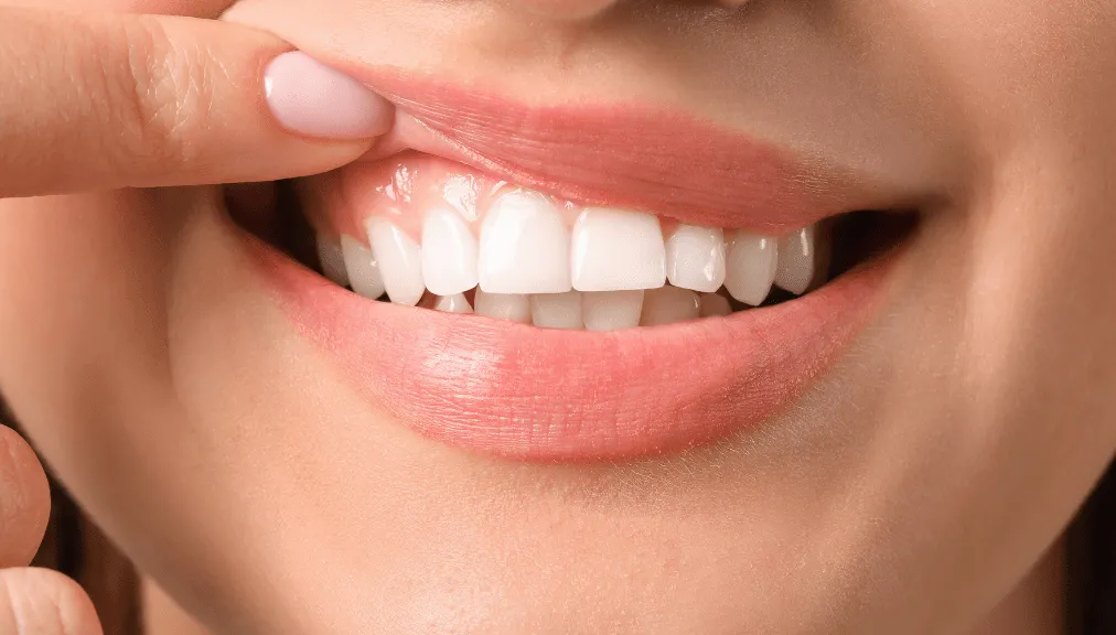 Woman smiling while caring for her gum health at home