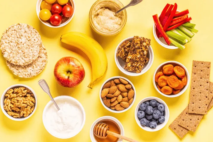 A colorful assortment of healthy snacks including apples, cheese, and vegetables