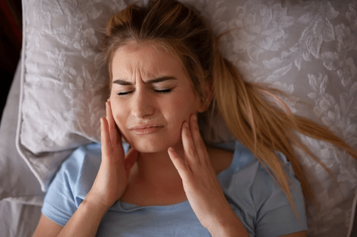 woman grinding teeth in bed